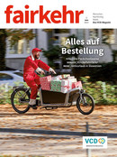 Auf dem Cover der fairkehr 5/2021 zum Thema Citylogistik fährt ein Mann im roten Overall ein Lastenfahrrad voller Weihnachtsgeschenke.