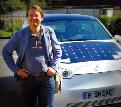 Autor Martin Unfried steht neben seinem Solarauto.